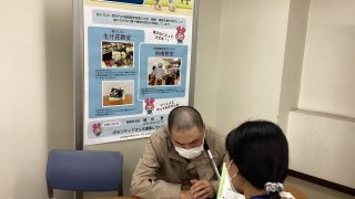 視覚部のコーナーで来場者と話す役員